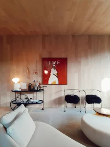 Sala d'estar minimalista amb parets de fusta clara, mobles moderns i una obra d'art cridanera, mostrant com combinar simplicitat i estil en la decoració de la llar