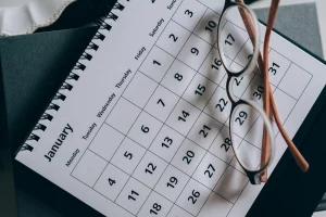 Calendar with glasses resting on it, symbolizing event planning in Barcelona.