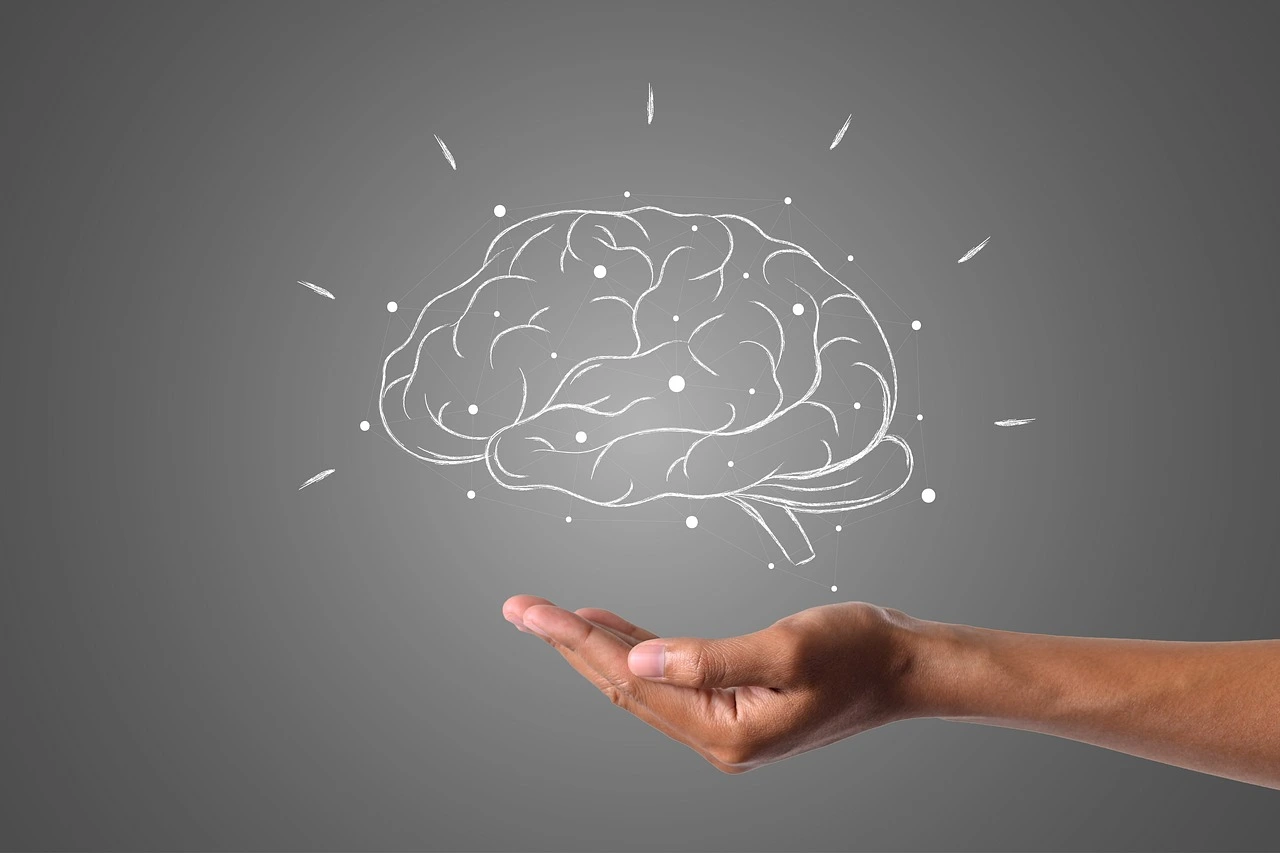 Hand holding a digital sketch of a brain with network connections
