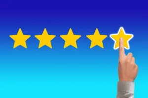 Una mano apuntando a la cuarta estrella en un sistema de calificación de cinco estrellas, simbolizando el acto de dar una calificación o reseña.