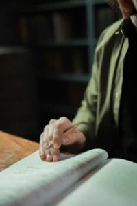 Primer plano de una mano señalando un texto legal o administrativo con un bolígrafo, en un entorno de oficina o estudio