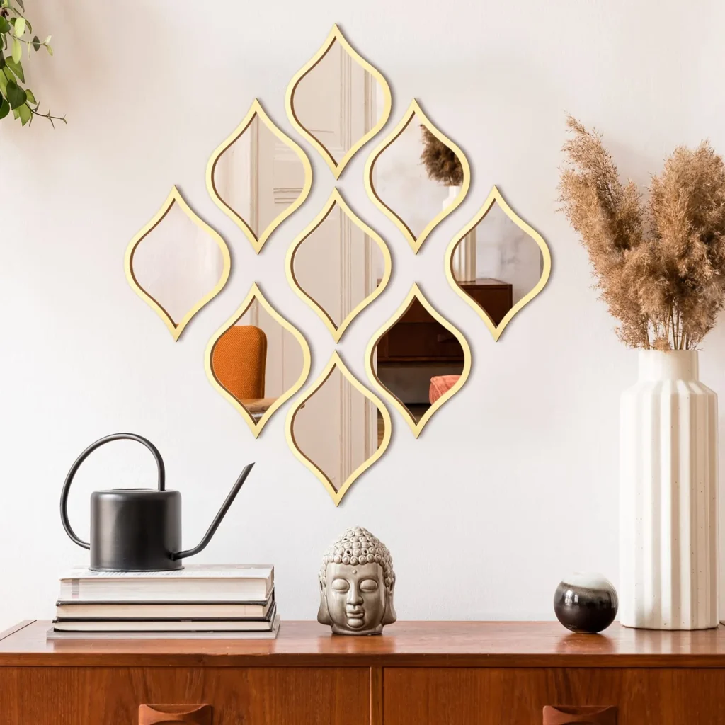 Decorative mirrors with gold geometric frames on a white wall, combined with a wooden console and decorative elements that create a warm and balanced style.