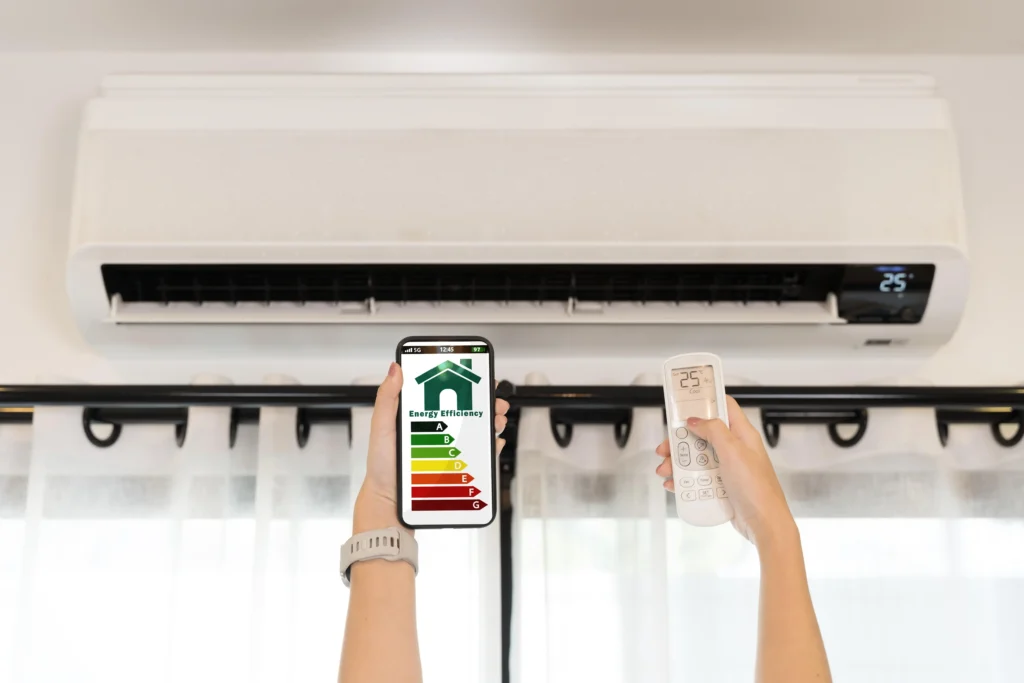Aire acondicionado en funcionamiento con control remoto y móvil mostrando eficiencia energética, ideal para optimizar consumo en vivienda o apartamento