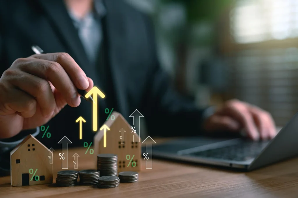 Concepto de inversión inmobiliaria con crecimiento del valor de una vivienda representado por casas, monedas y flechas ascendentes