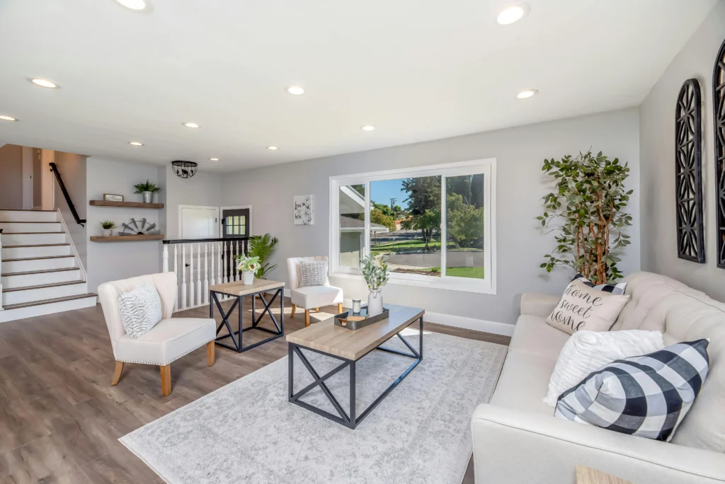 Salón amplio y luminoso con sofá, mesa de centro y grandes ventanas, ideal para alojamiento o vivienda moderna