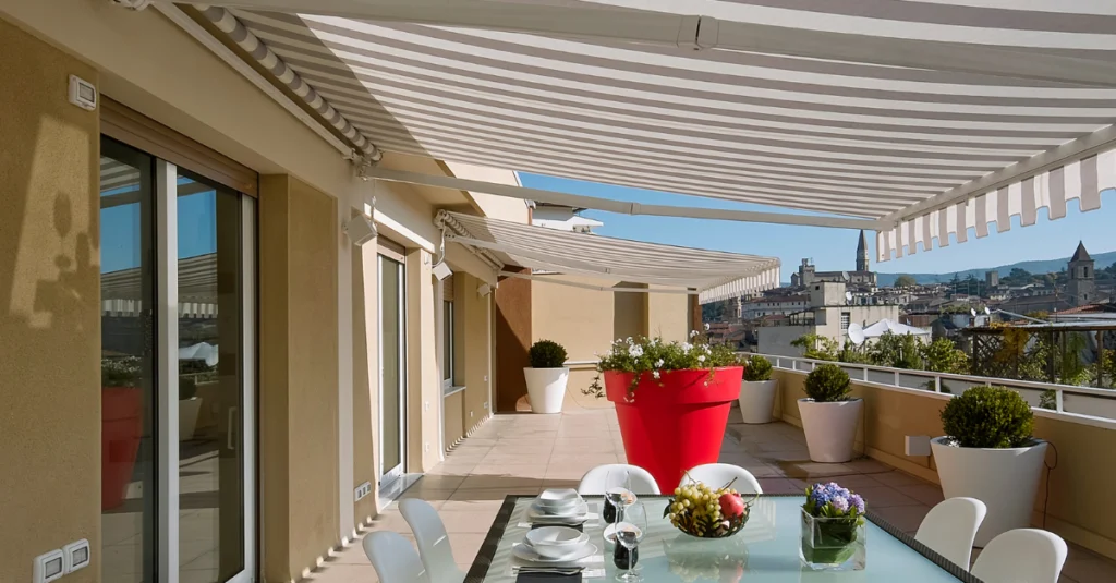 Terrassa àmplia amb tendals, taula de menjador exterior i plantes decoratives, ideal per gaudir de l’espai en temporada alta