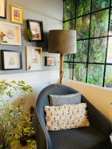 Cosy corner of a holiday rental with an armchair, cushions, plants and decorative pictures that add personality and a welcoming atmosphere