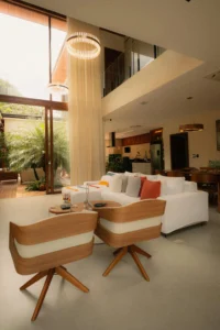 Spacious holiday rental living room with modern design, large windows, natural light and access to a terrace with plants