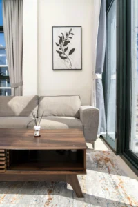 Holiday rental living room with a sofa, wooden table and large windows that provide natural light and a sense of comfort