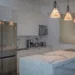 Cocina moderna de apartamento con isla de mármol, frigorífico de acero inoxidable y lámparas colgantes contemporáneas.