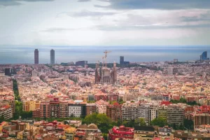 Panoramic view of Barcelona, with the Sagrada Familia in the center and the Mediterranean Sea in the background, showcasing the beauty and diversity of the city.