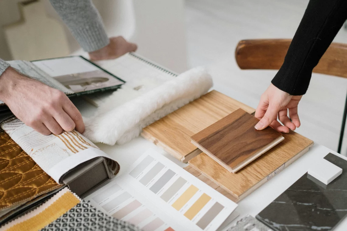 Muestras de madera, tela y colores en una mesa de diseño para elegir combinaciones decorativas.