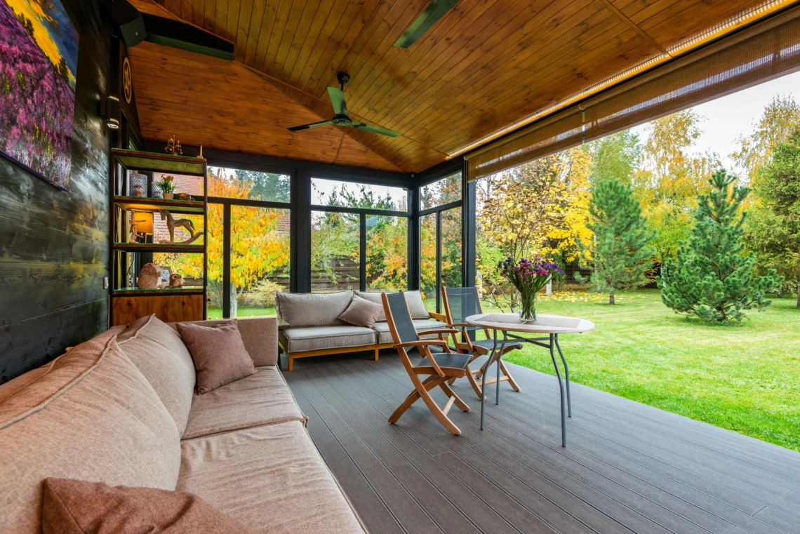 Relax on a glass-walled terrace with views of the garden in autumn.