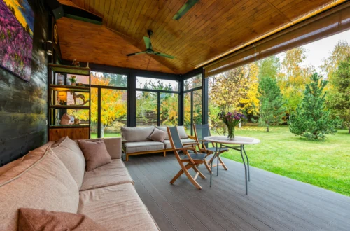 Relax on a glass-walled terrace with views of the garden in autumn.