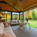 Relax on a glass-walled terrace with views of the garden in autumn.