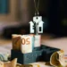 House key with home-shaped keychain hanging above euro banknotes in a miniature building model