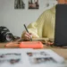 Person editing photos on a computer with a professional camera on the desk, representing the behind-the-scenes work of capturing images for a vacation rental apartment.