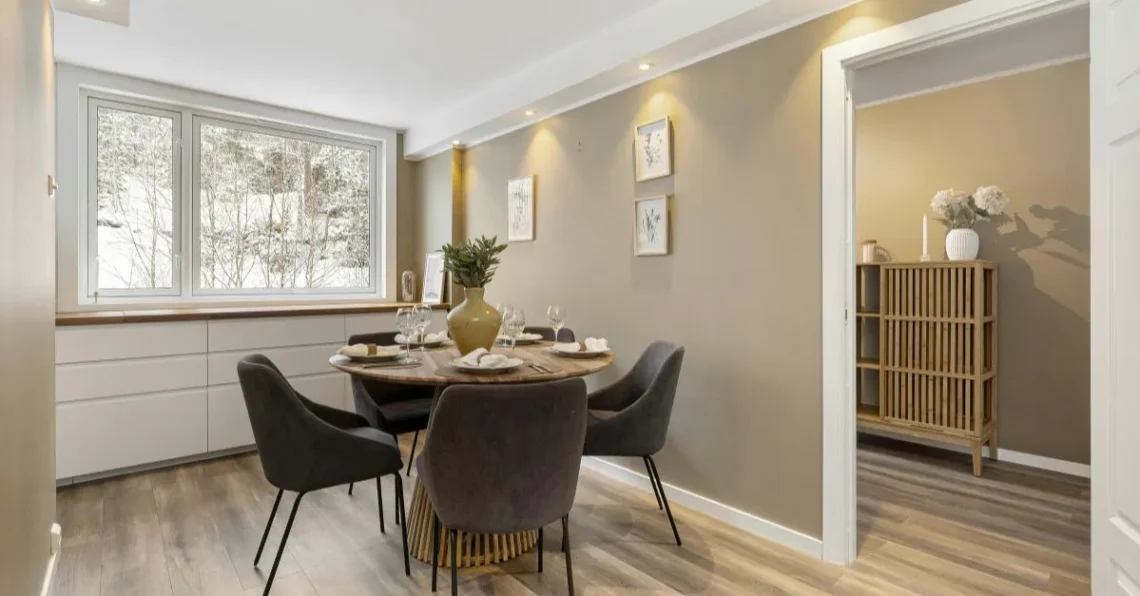 Comedor de apartamento con diseño moderno y funcional, con mesa redonda, sillas cómodas y buena iluminación natural