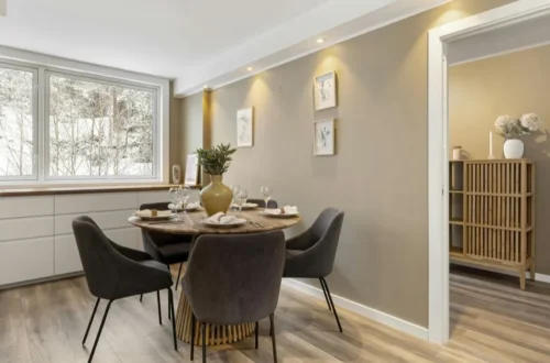 Comedor de apartamento con diseño moderno y funcional, con mesa redonda, sillas cómodas y buena iluminación natural